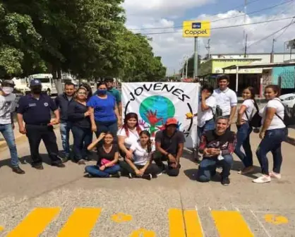 Jóvenes pintan paso peatonal de la plazuela Benito Juárez en Villa Juárez