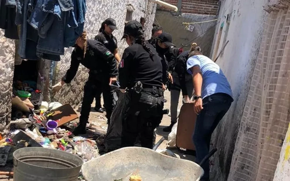 Policías limpian el hogar de una familia que vivían entre la basura