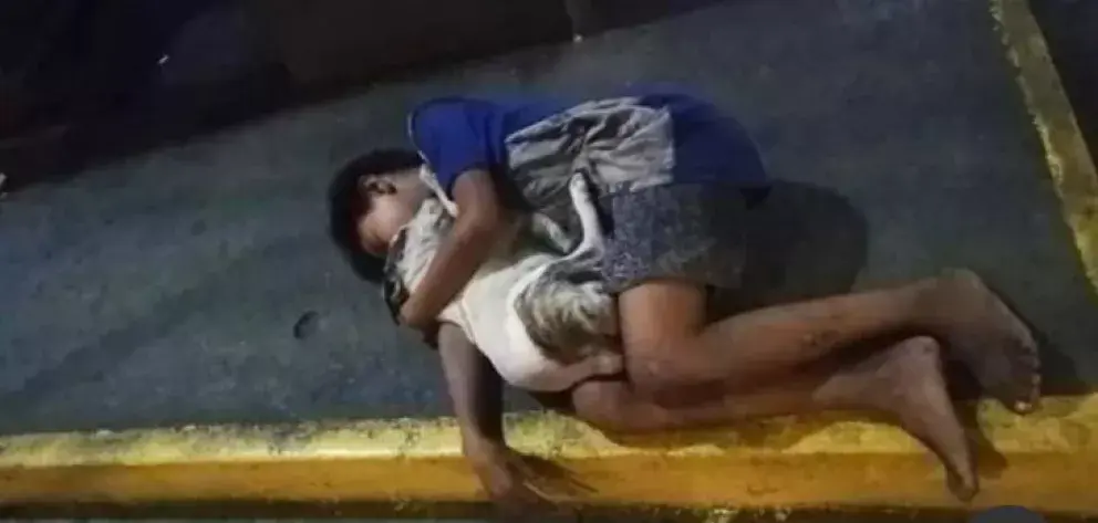 Un niño y su perro se abrazan fuerte para enfrentar el frío de la noche