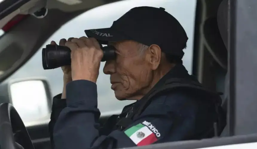 Nefi de Aquino, quien trabaja como oficial de policía y también vigila la actividad del Popocatépetl, observa el volcán a través de sus binoculares desde Santiago Xalitzintla, México, el jueves 25 de mayo de 2023. (AP Foto/Marco Ugarte)