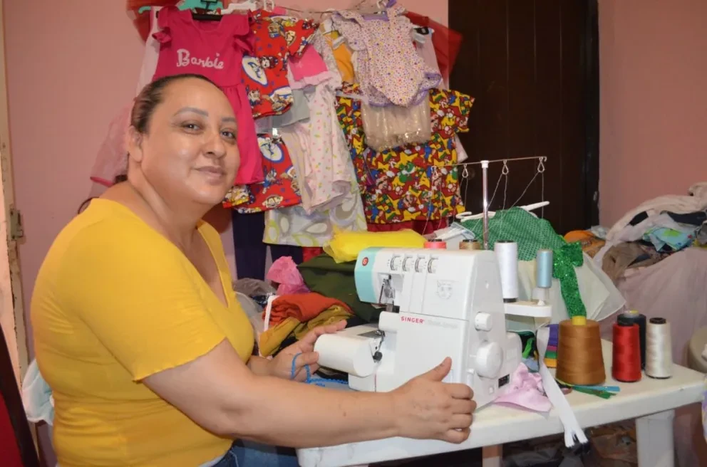 Entre telas de diferentes tipos y colores, cinta métrica, tijeras, hilos, agujas, alfileres y una serie de materiales y herramientas que le facilitan el trabajo a Nelyta, en la colonia 5 de Febrero arregla y confecciona ropa,.