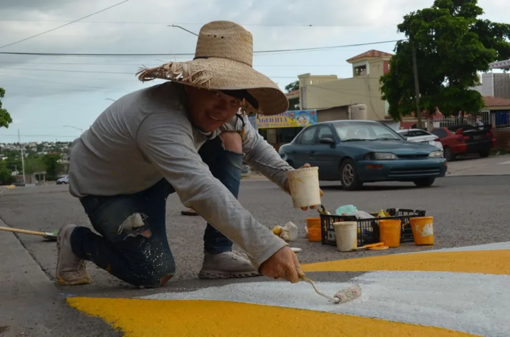 Julio Alberto necesitaba llevar dinero a su hogar y puso mano a la obra: actualmente se dedica a pintar topes en Culiacán de manera voluntaria.  Fotos: Juan Madrigal