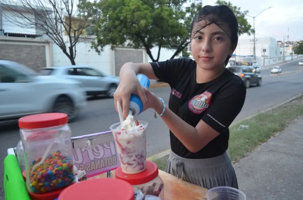 Perlita y su mamá Yessica, realizan por las tarde-noche la venta de snacks, en las canchas deportivas San Pío, en la colonia Progreso y ofertan deliciosas fresas con crema sobre la avenida México 68, a la altura de Parque Culiacán. Fotos: Juan Madrigal