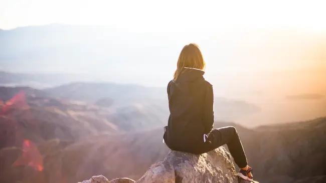 Mujer escalando una montaña. Pixabay
