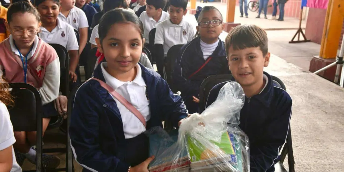 Niños y niñas reciben una dotación de libros.