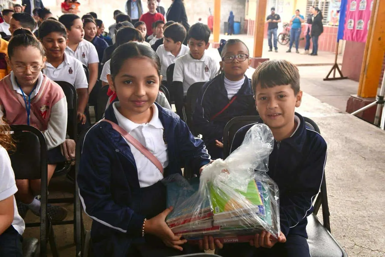 Niños y niñas reciben una dotación de libros.