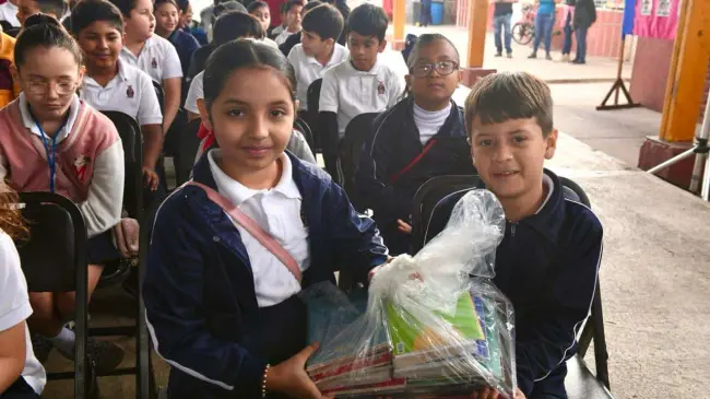 Niños y niñas reciben una dotación de libros.