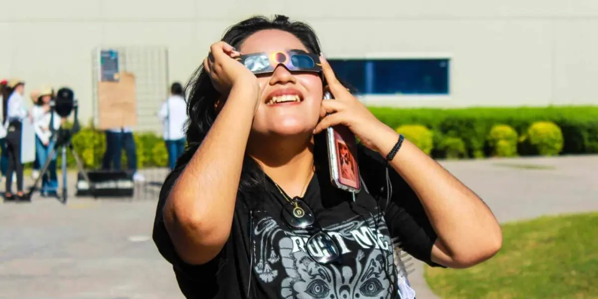 Niña observando un eclipse con lentes adecuados.