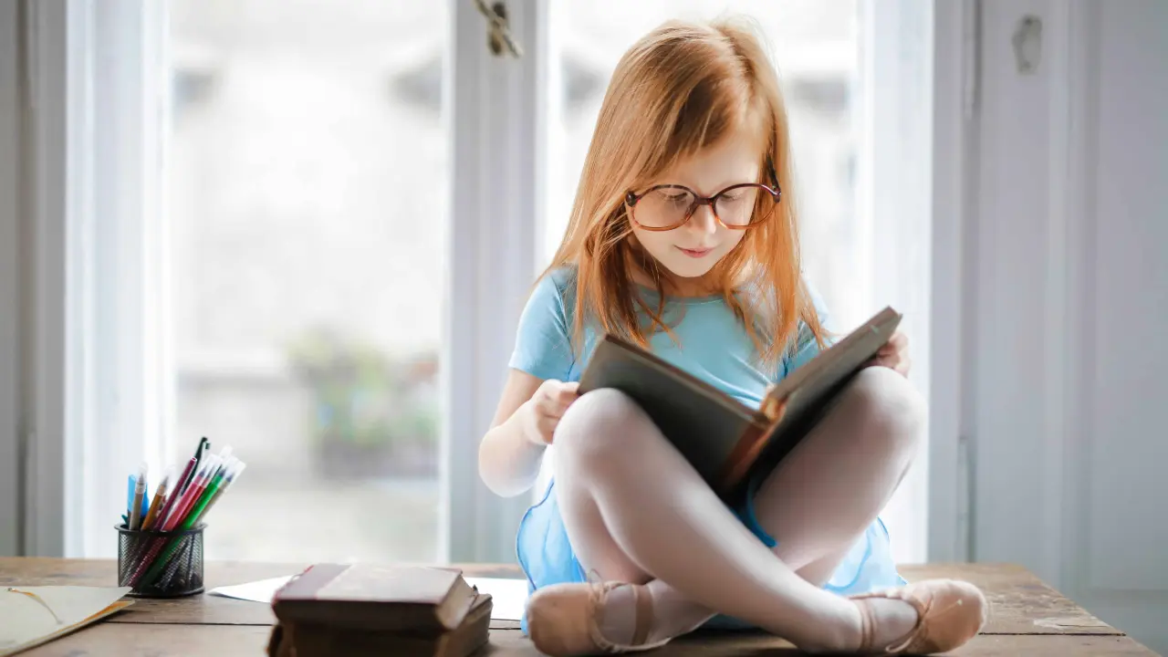 Niña disfrutando de la lectura. Foto Pexels