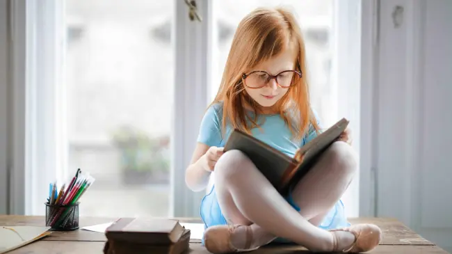 Niña disfrutando de la lectura. Foto Pexels