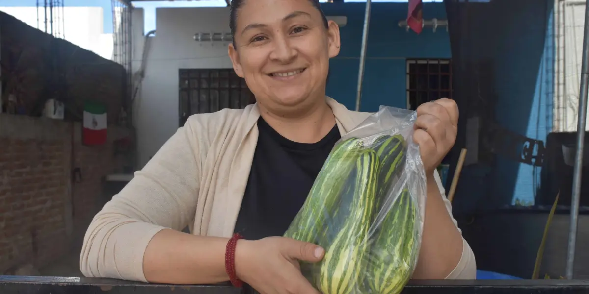 De muy buen ánimo Lupita vende sus calabazas en la puerta de su hogar.