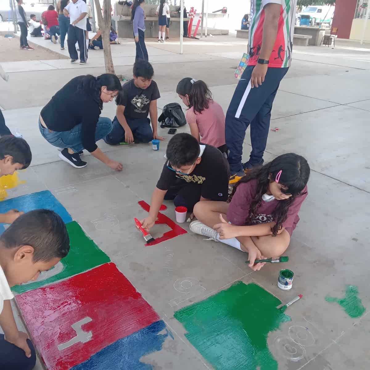 Niños pintando en su proyecto escolar