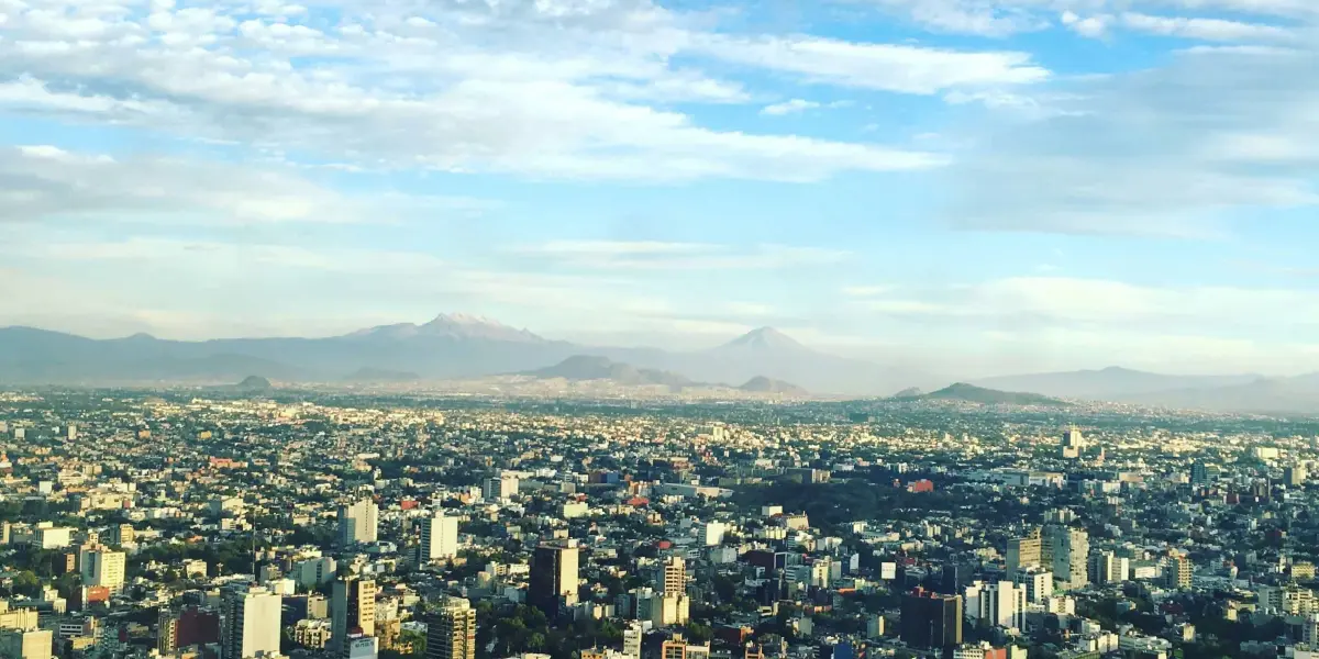 Imagen aérea de la Ciudad de México de día.  Foto de <a href=https://unsplash.com/es/@alexistostado?utm_content=creditCopyText&utm_medium=referral&utm_source=unsplash>Alexis Tostado</a> en <a href=https://unsplash.com/es/fotos/foto-aerea-de-edificios-de-hormigon-bajo-nubes-blancas-durante-el-dia-3TBuSLluZ8w?utm_content=creditCopyText&utm_medium=referral&utm_source=unsplash>Unsplash</a>