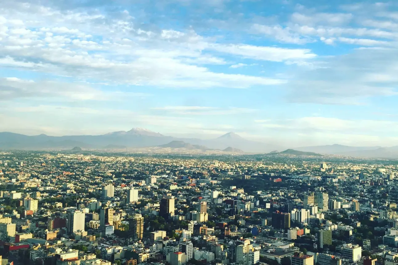 Imagen aérea de la Ciudad de México de día.  Foto de <a href=https://unsplash.com/es/@alexistostado?utm_content=creditCopyText&utm_medium=referral&utm_source=unsplash>Alexis Tostado</a> en <a href=https://unsplash.com/es/fotos/foto-aerea-de-edificios-de-hormigon-bajo-nubes-blancas-durante-el-dia-3TBuSLluZ8w?utm_content=creditCopyText&utm_medium=referral&utm_source=unsplash>Unsplash</a>