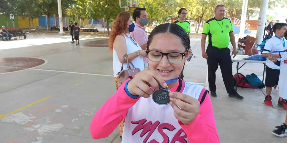 Muy emocionada Analu recibe sus medallas como basquetbolista.