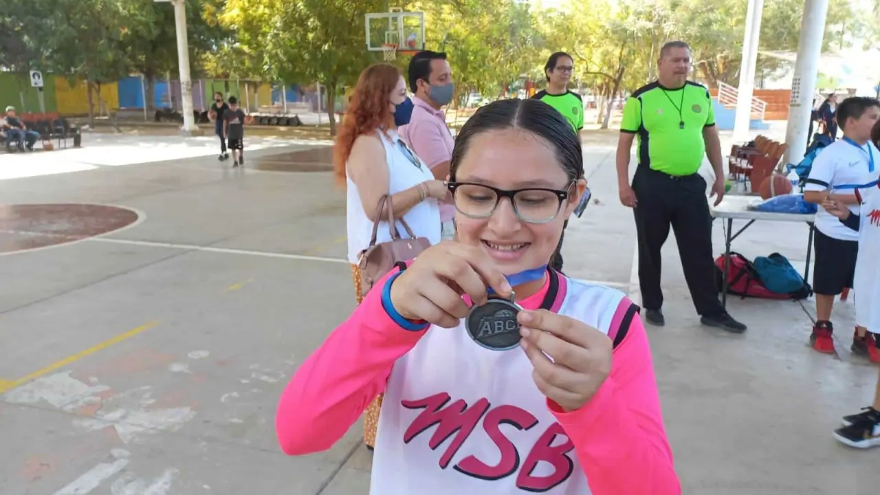 Muy emocionada Analu recibe sus medallas como basquetbolista.