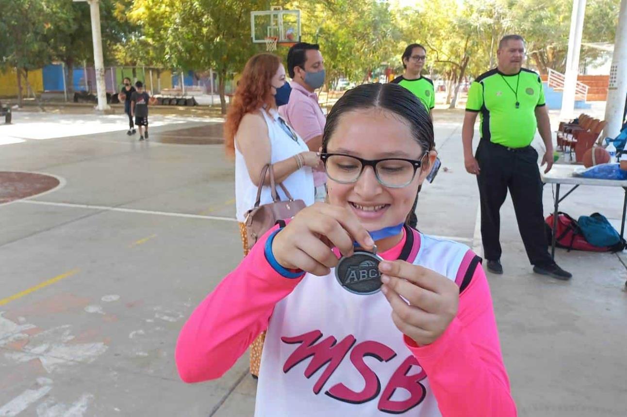 Muy emocionada Analu recibe sus medallas como basquetbolista.
