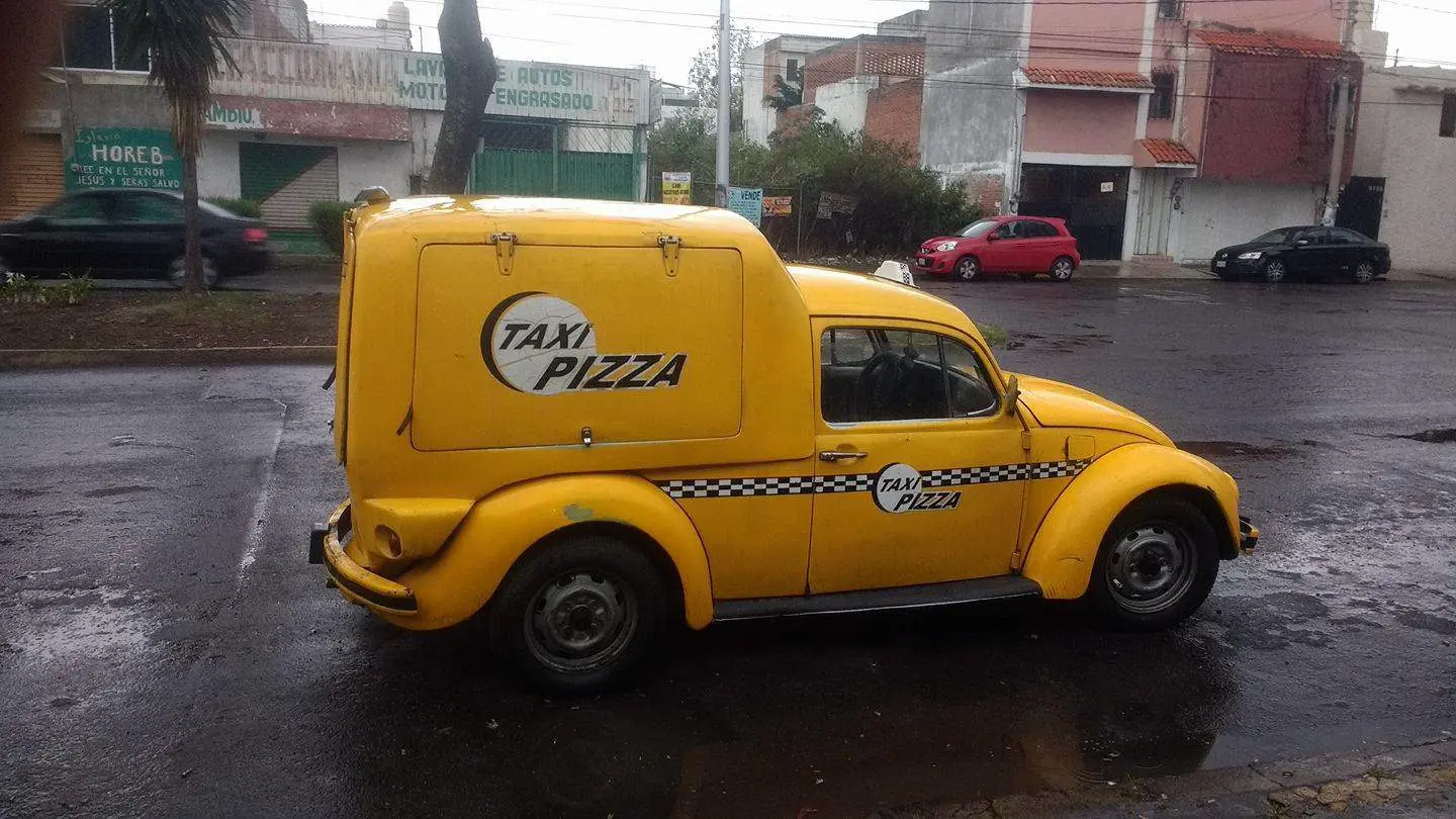 Taxi pizza, el bocho amarillo que le vende pizzas a alumnos universitarios de Puebla. Foto FB Taxi Pizza