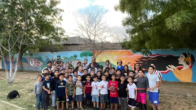 El mural, que adorna la barda del espacio recreativo, transmite mensajes de esperanza, unidad y valores fundamentales como el fomento del deporte, la prevención de la violencia y la construcción de paz.