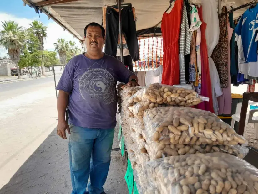 A orilla de calle tiene el puesto y el horno tostador