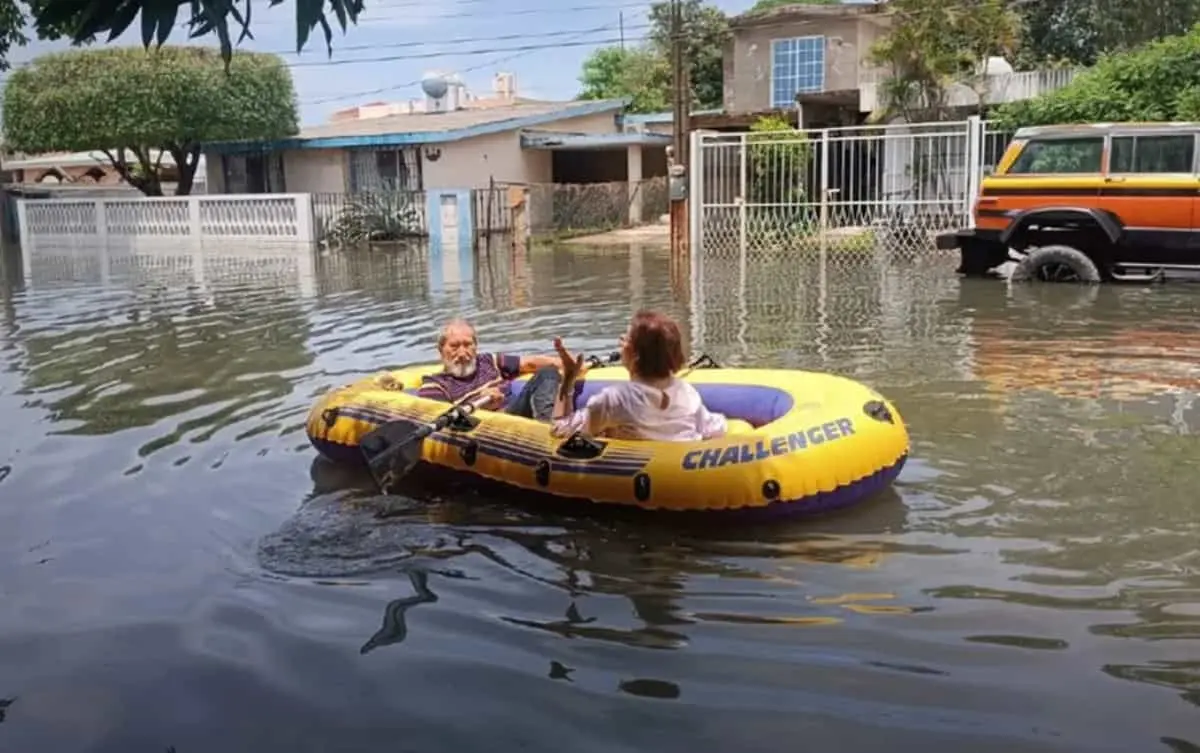 Abuelitos salen a comprar pollo en lancha inflable tras inundaciones en Tamaulipas.