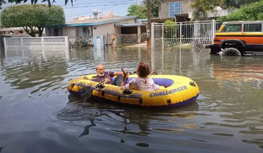 Abuelitos salen a comprar pollo en lancha inflable tras inundaciones en Tamaulipas.