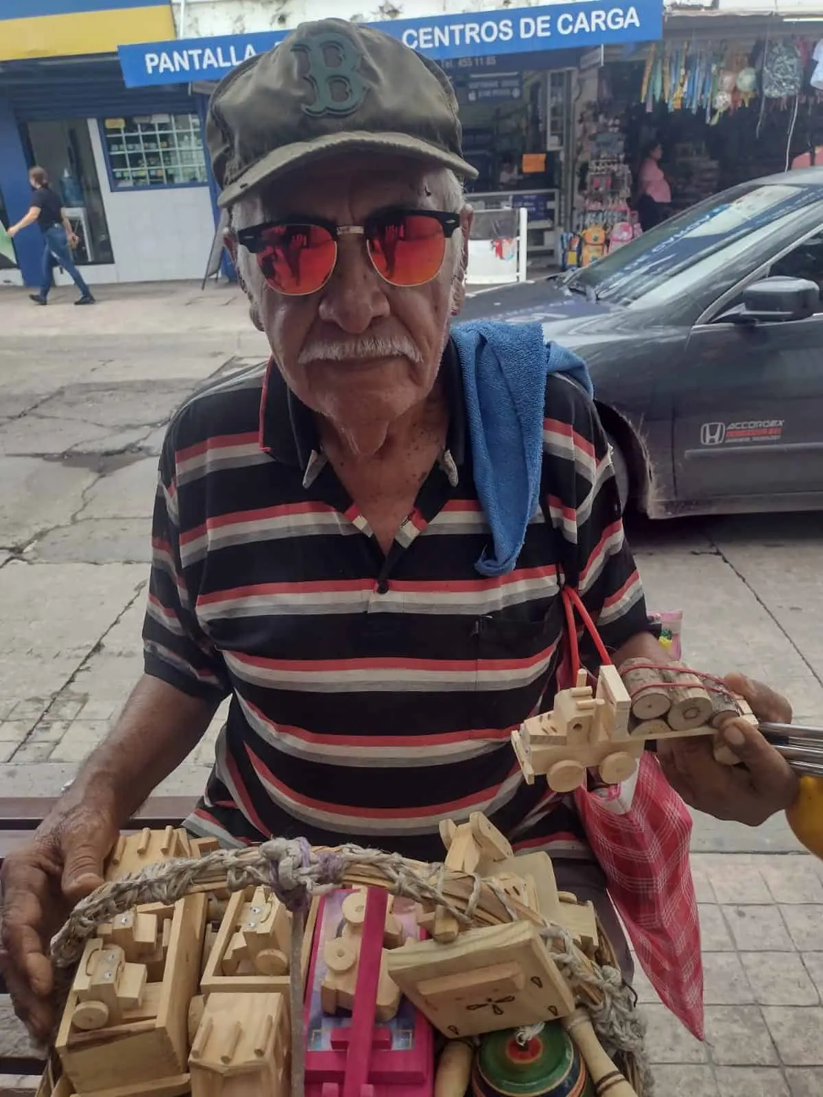 Con muy buen ánimo, don Lalo sale a vender sus carritos de madera.