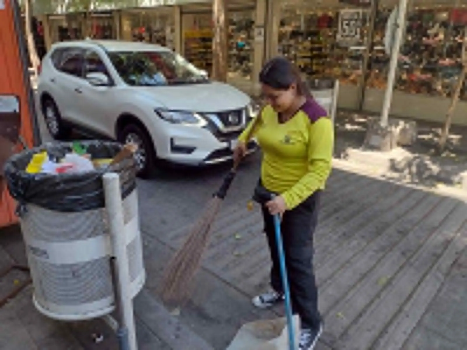 Con su escoba y un recogedor, trabaja para mantener limpia su área de trabajo.