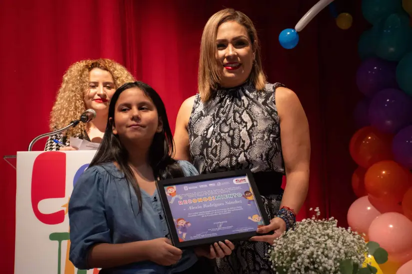 Con mucho orgullo Alexia Rodríguez recibió el premio como Niña Cronista de manos de la Secretaría de Bienestar Municipal, Aline Krystabel Guerra. Alexia Rodríguez recibió el premio como Niña Cronista de manos de la Secretaría de Bienestar Municipal, Aline Krystabel Guerra.
