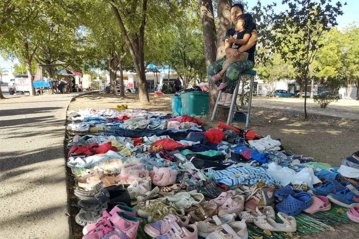 Marlén Muñoz, acompañada de su hija de 2 años, atiende su puesto de venta de ropa en un parque de Los Ángeles. Foto: Francisco Castro