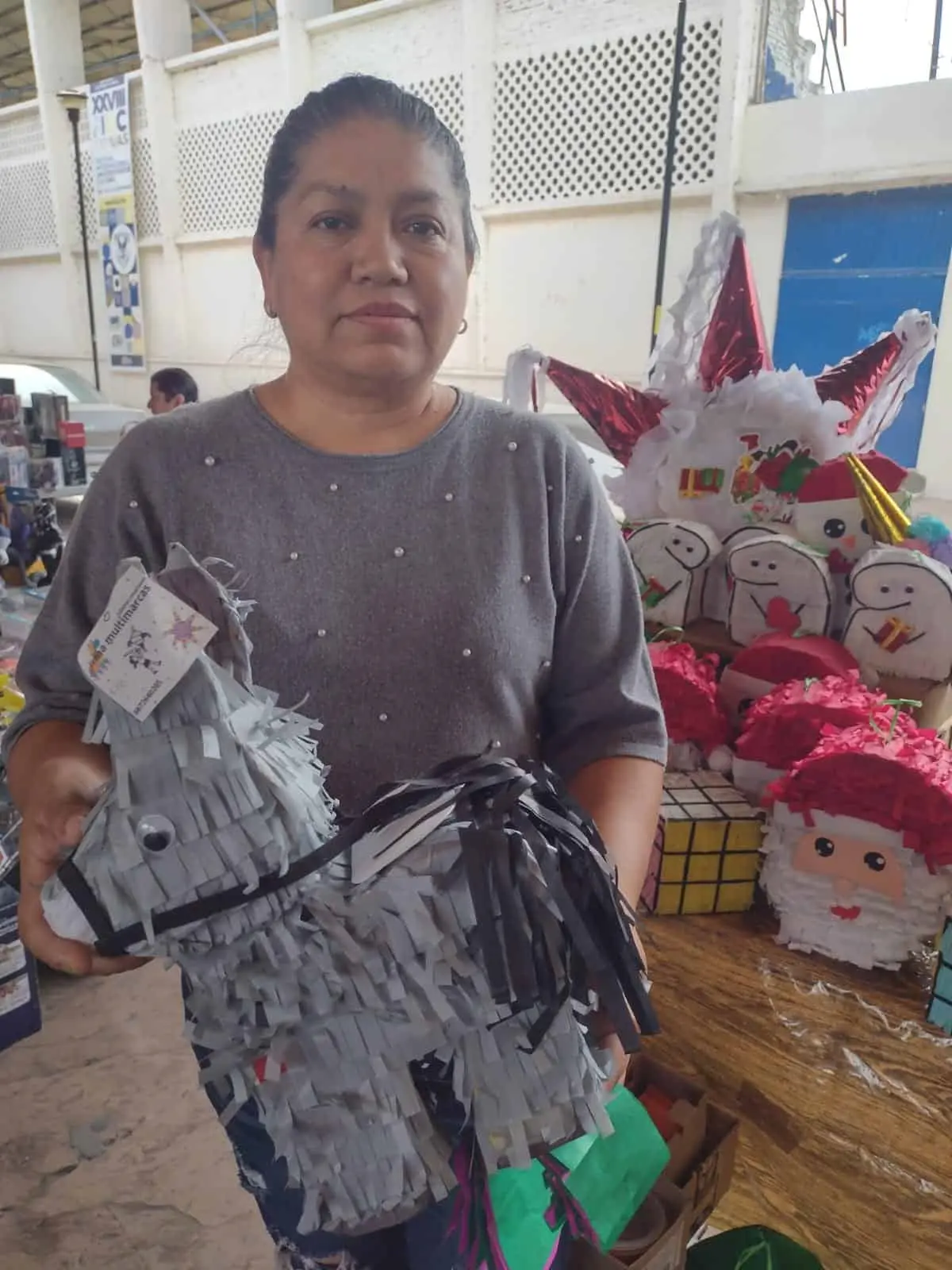 Con muy buen ánimo, Irma Hernández arma sus piñatas y las vende.