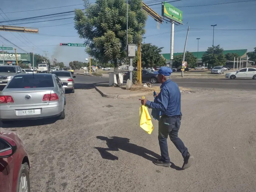 Don Chano camina entre los automóviles para vender sus toallitas y bolsas negras.