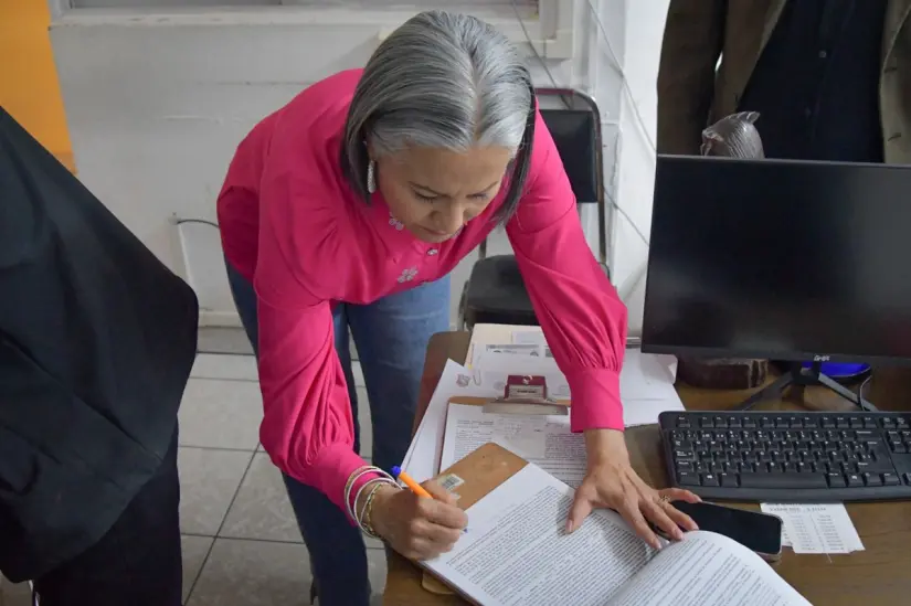 Presidenta Lupita López González, firmando el indulto que permitiría la liberación de los detenidos.