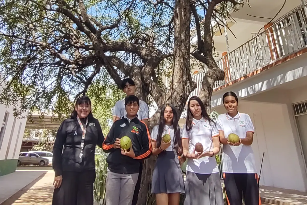 La maestra Dulce María Muy Rangel y estudiantes del CECyTE de Loma de Rodriguera, posan frente al centenario árbol de Ayale que está en el patio del plantel.