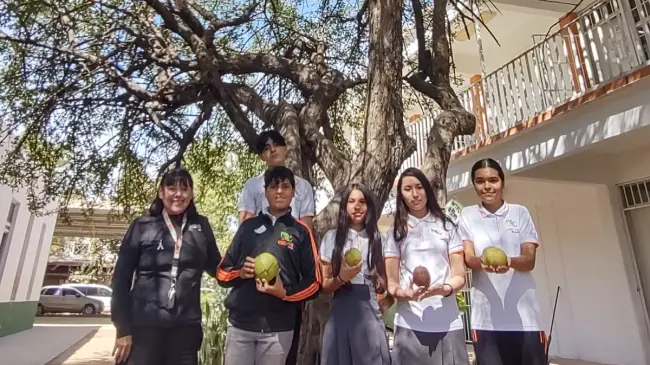 La maestra Dulce María Muy Rangel y estudiantes del CECyTE de Loma de Rodriguera, posan frente al centenario árbol de Ayale que está en el patio del plantel.