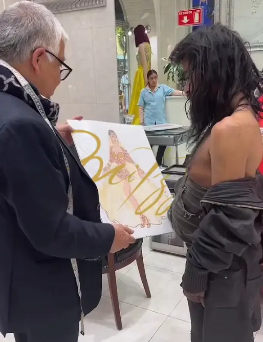 Mitzy mostrando bocetos de sus diesños a la Diva Indigente 