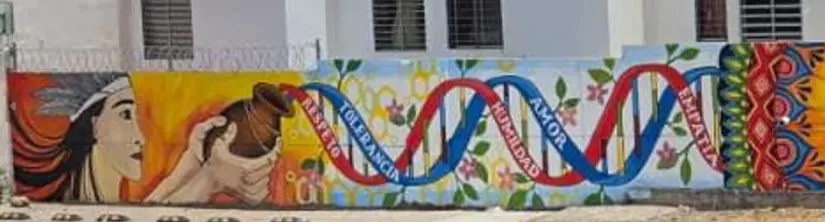 La figura del indígena cargando una olla de donde emerge la cadena de ADN es crucial en este mural.