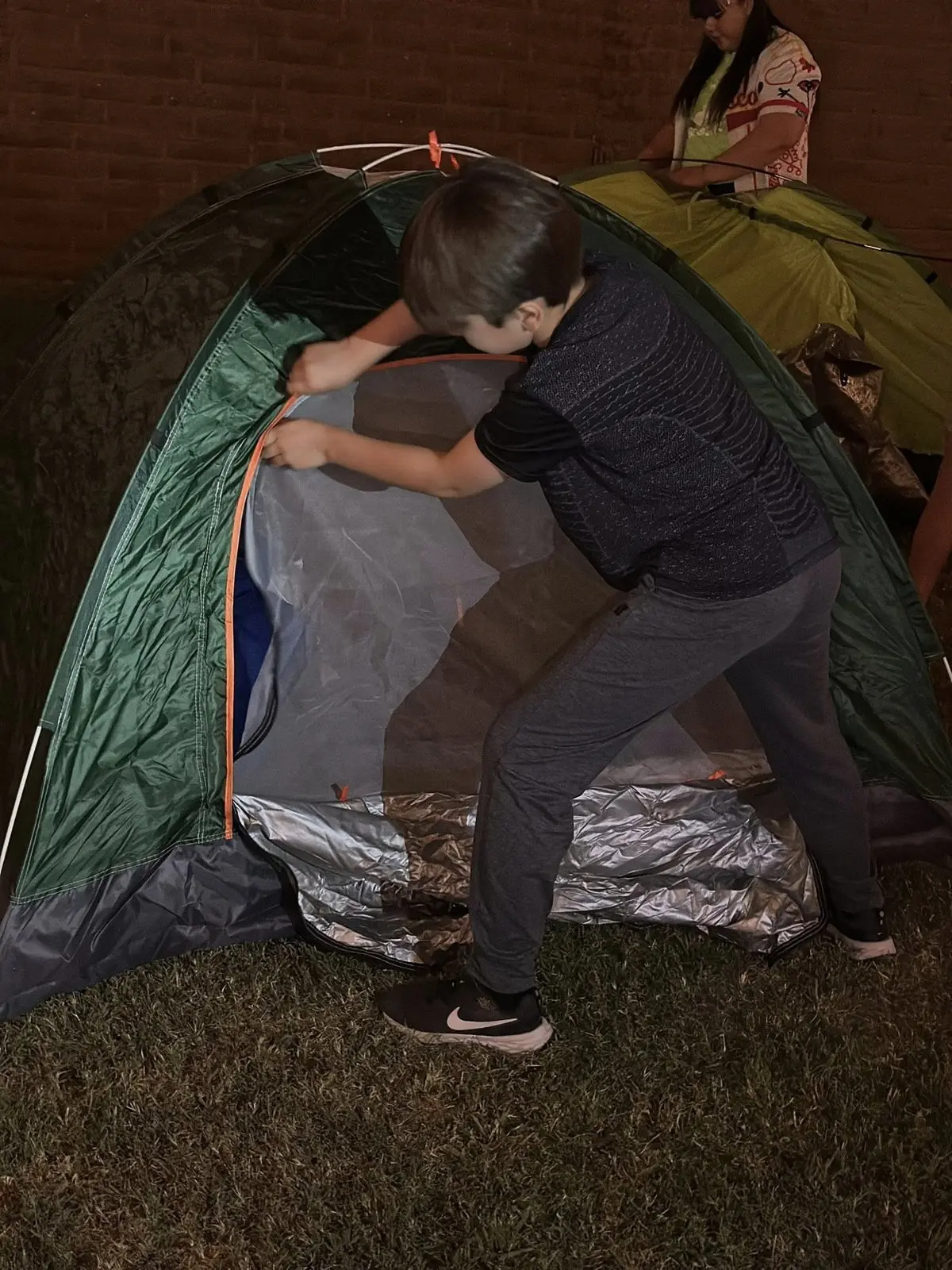 Niño armando tienda de campaña en el Campamento 