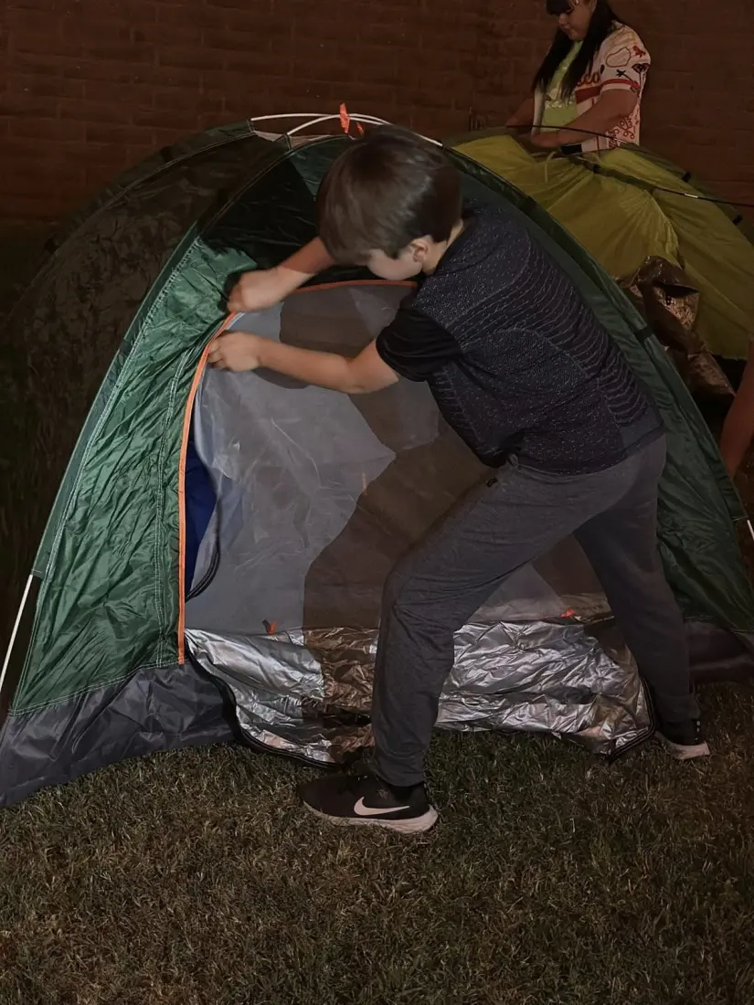 imagen recuadro Niño armando tienda de campaña en el Campamento