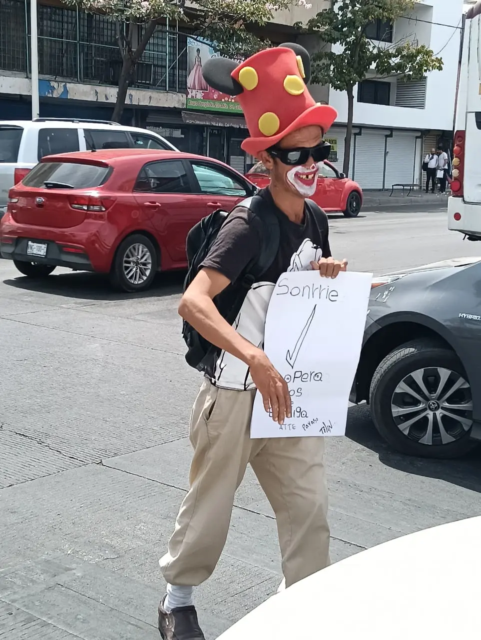 En medio de los carros se gana la vida y saca una sonrisa a los automovilistas.