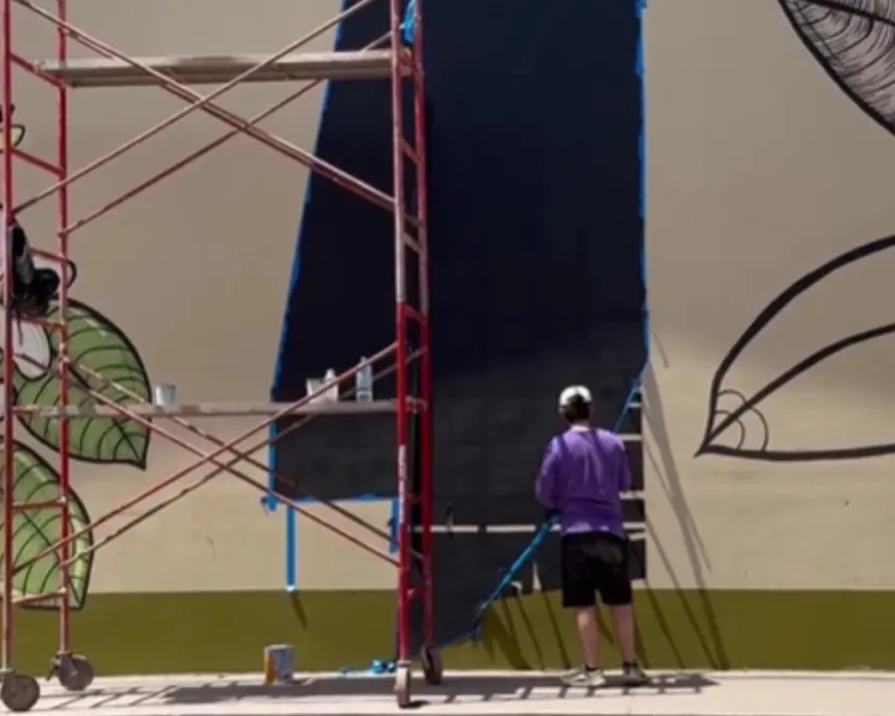 Momento en que el artista Alejandro Castañeda pinta el mural en el emblemático Mercado de Tierra Blanca.