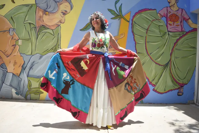 imagen recuadro Amparo Torróntegui muestra un traje regional de la sierra de Sinaloa. Es un vestido confeccionado por ella misma en 1979. Tiene pintado algunos símbolos y escenarios representativos del estado, como la flor de la sierra, Barras de Piaxtla, el mar y Mazatlán.
