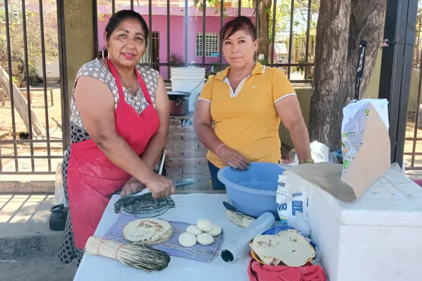 imagen recuadro Dora y Candelaria, emparentadas con la unión de sus hijos, emprendieron juntas con la venta de comida en la avenida principal de Loa de Rodriguera.