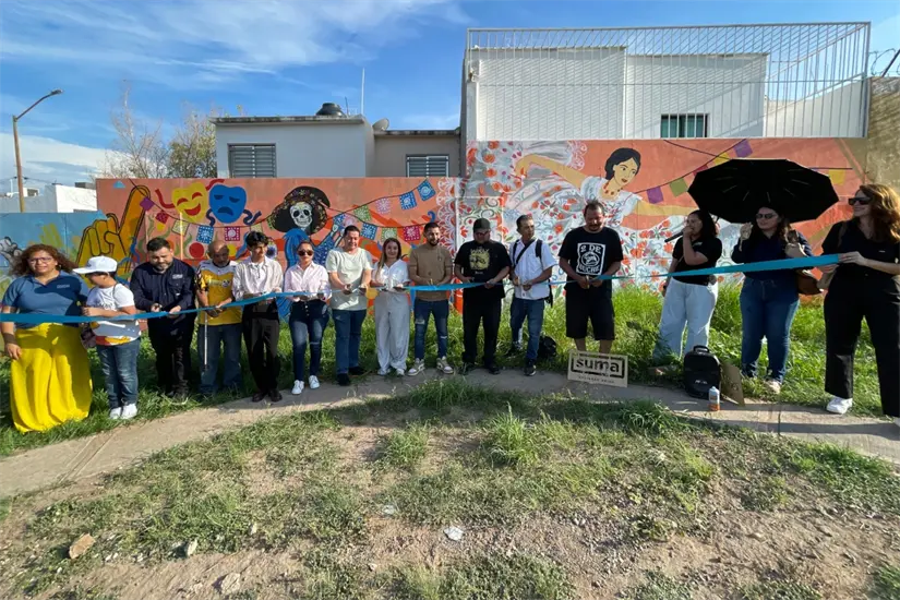Momento en que representantes de SUMA, Sociedad Unida, y del programa Vamos Pintando inauguran la serie de murales de paz, con vecinos como testigos.
