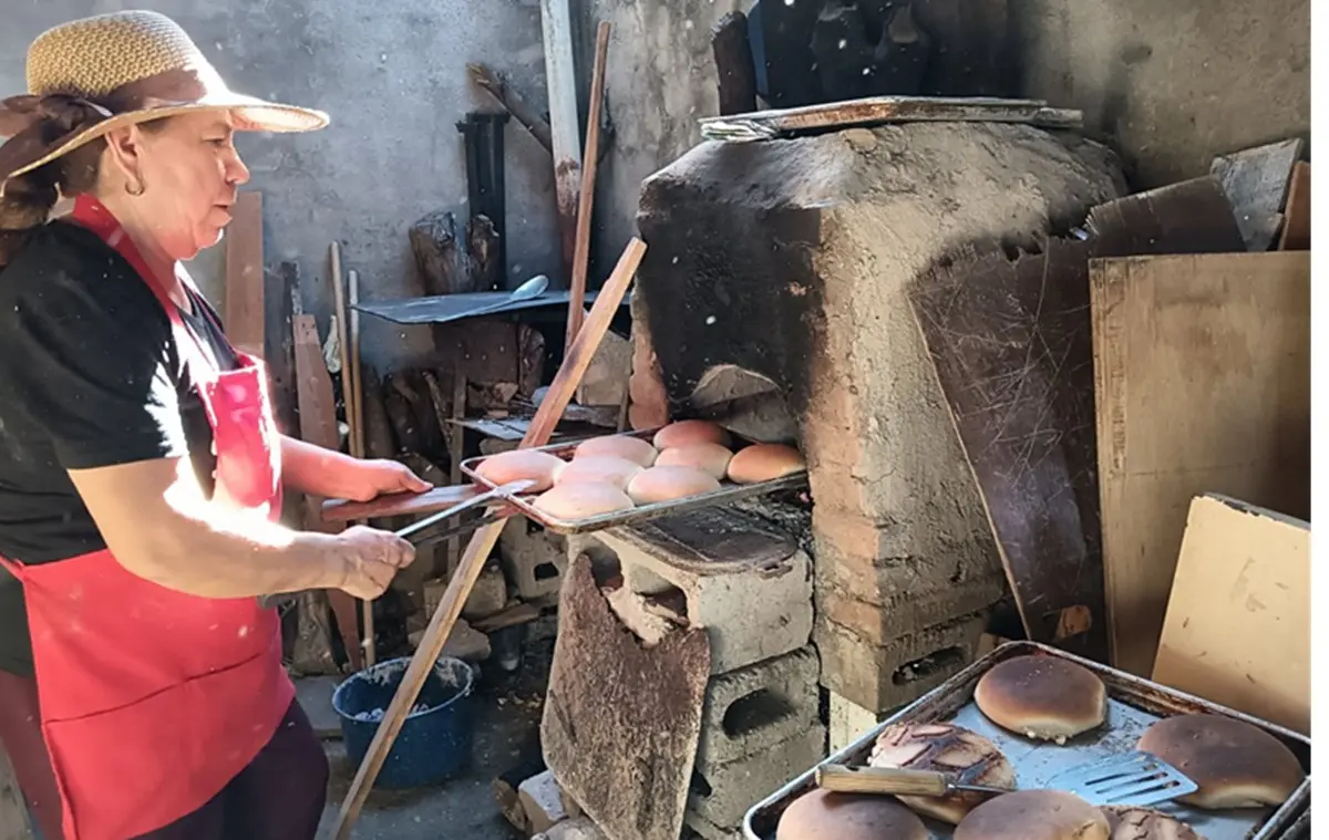 Tras perder a su esposo y a dos de sus hijos hace 15 años, doña Juanita aprendió por su cuenta a hacer pan y convirtió un horno rústico en el patio de su casa en su principal forma de sustento. | Imágenes de Francisco Castro