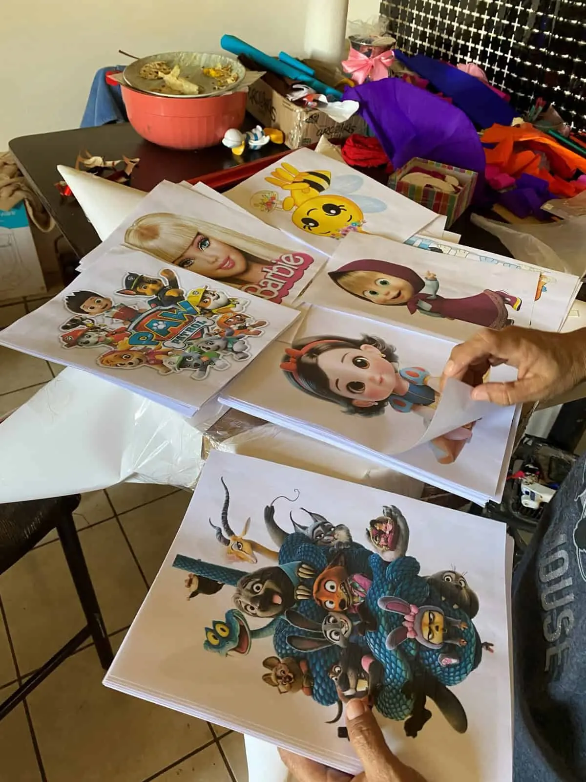 Juani muestra algunas de las múltiples imágenes que utiliza para la elaboración de piñatas infantiles