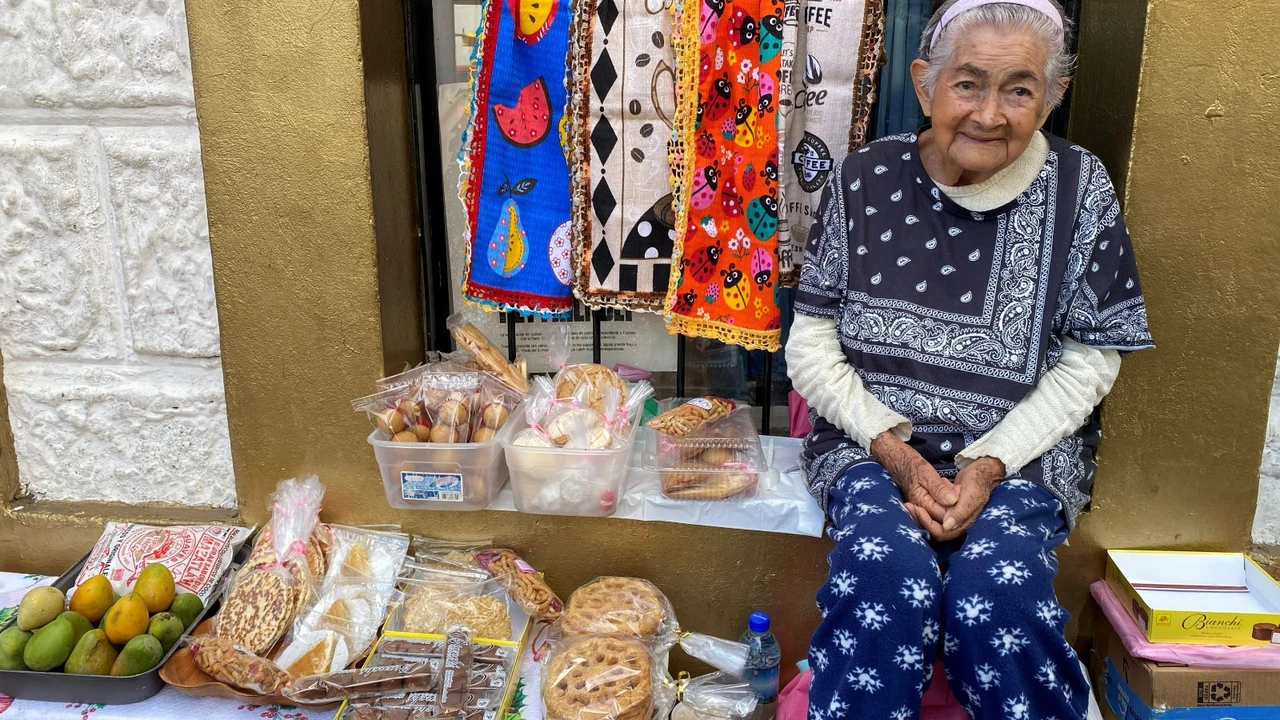 Con una sonrisa y mucha energía, doña Carmen vende productos hechos en casa junto a sus hijas. A sus 91 años asegura que trabajar le sirve de terapia y le da motivos para seguir adelante.