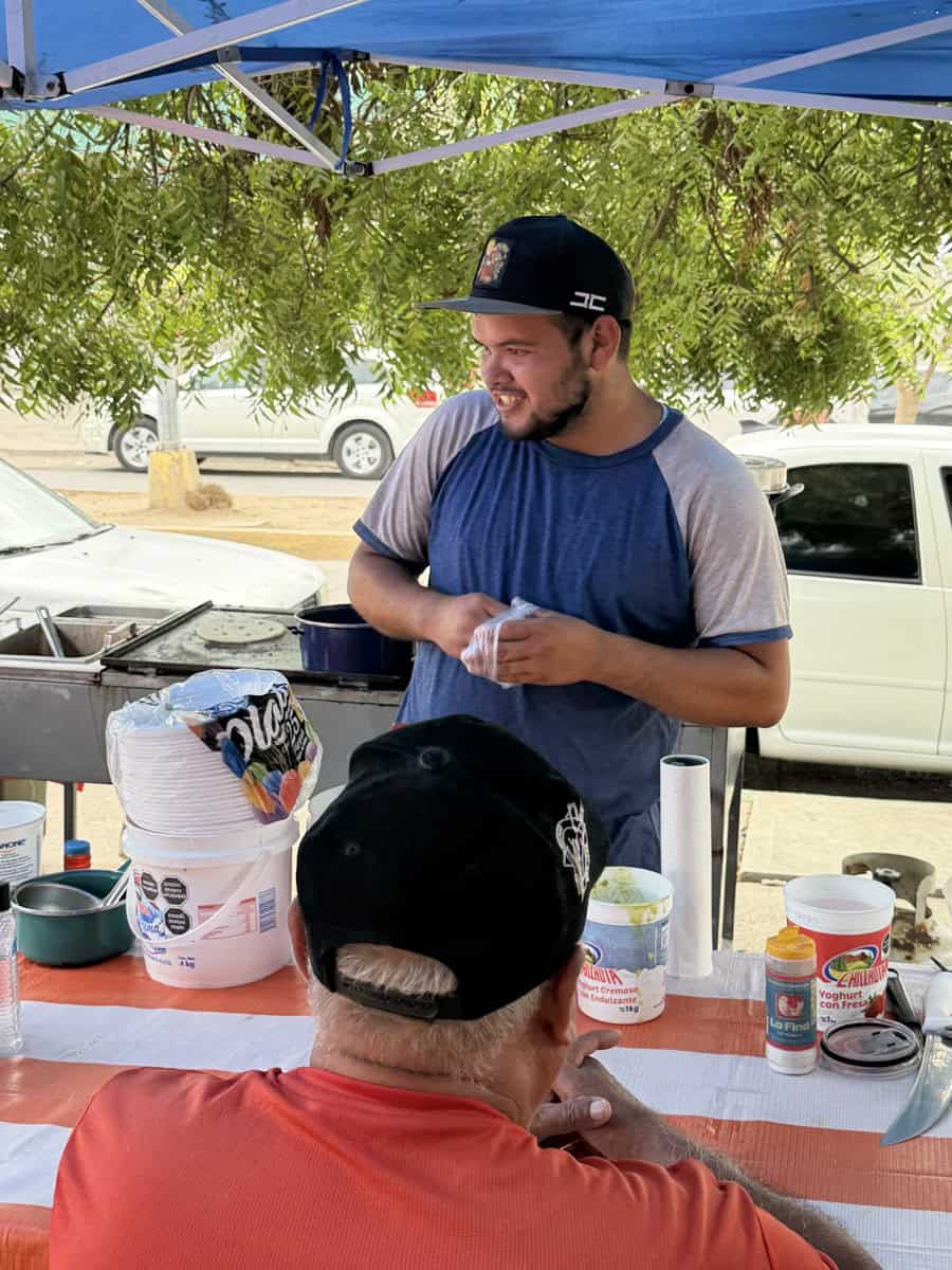Carlos, el mayor de los hermanos, prepara la birria y las aguas frescas para el negocio, su condición no le impide ser responsable y disfrutar de su labor en el negocio