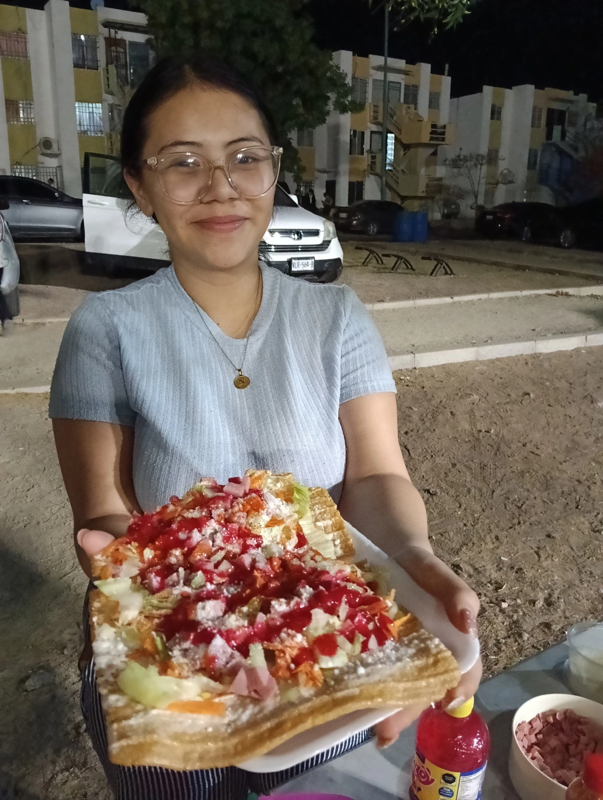 Entusiasmada, Natalie Naomi muestra el producto que tiene a la venta para todos los vecinos de Alturas del Sur.
