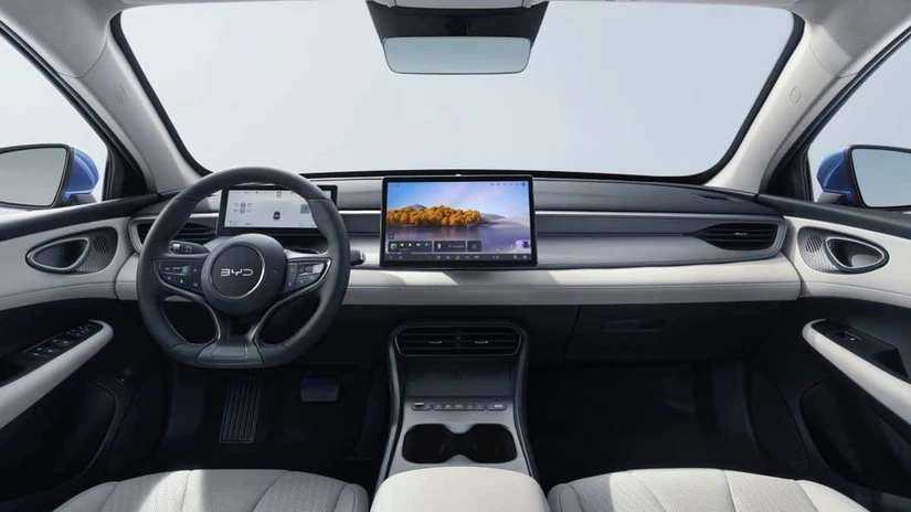 El display rotativo llega hasta 15.6 pulgadas según la versión, con Apple CarPlay y Android Auto inalámbricos. El coche también acepta llave digital por NFC: basta acercar el celular al espejo lateral para abrirlo.
